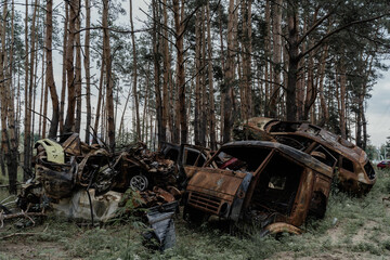 old car in the forest 
left burned after the Russian invasion of Ukraine
