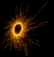 Ring made of sparklers on a black background.