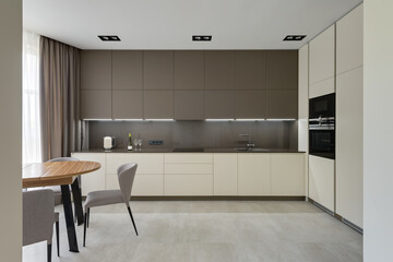 modern kitchen interior, kitchen with dining table in modern style, large modern kitchen in beige brown tones