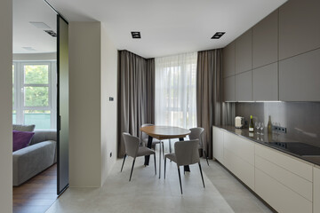 Fototapeta na wymiar modern kitchen interior, kitchen with dining table in modern style, large modern kitchen in beige brown tones
