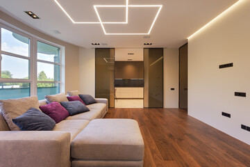 living room in a modern city apartment with designer lighting and sliding doors, living room in a modern apartment with a large gray sofa