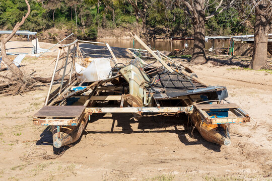 Photograph of a flood damaged boat on a white sandy area of land
