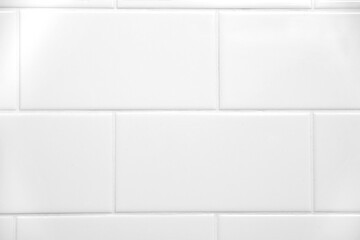 White tiled wall. White tiles and grout of a bathroom wall. Close-up showing tiles and grout
