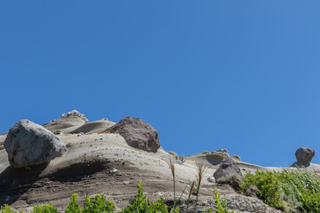 青空と雨風に削られてできた階段状の岩場