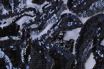 Black transparent fabric decorated with sequin flowers print textured background