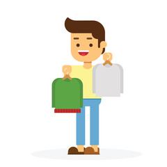 Young man chooses clothes on hanger on shopping