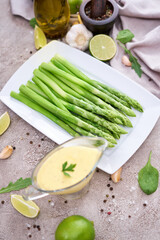 Green organic natural Asparagus in ceramic white plate on kitchen table
