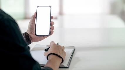 Mockup image blank white screen cell phone. Man hand holding using mobile rat office. background empty space for advertise text.