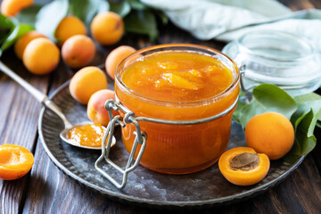 Homemade preservation. Delicious apricots jam or jelly on a rustic wooden table.