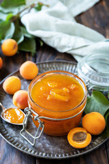 Homemade preservation. Delicious apricots jam or jelly on a rustic wooden table.