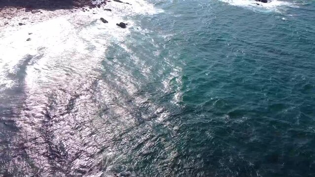 Vista est&aacute;tica del oc&eacute;ano y el mar con las olas golpeando las rocas de una playa en el acantilado
