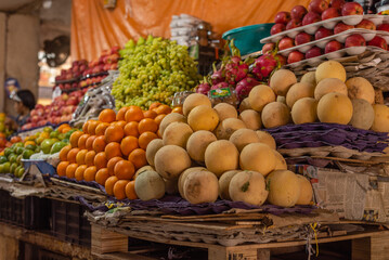 Fruits and vegetables on display in a market setup. Inflation and essential commodities.