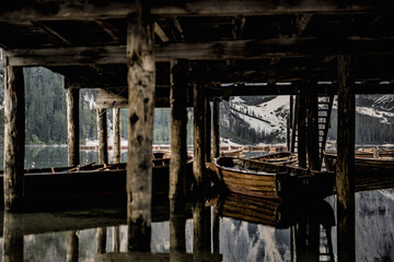 Amazing view on boats under lake house on Braies Lake in Dolomites mountains in the morning. Braies Lake (Pragser Wildsee, Lago di Braies), Dolomites, South Tirol, Italy, Europe.