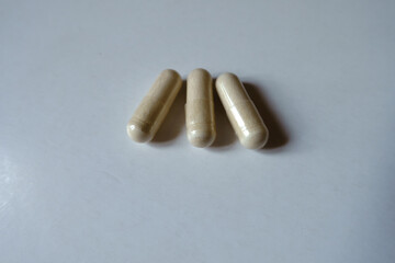Close view of three light beige capsules of Saccharomyces boulardii probiotic