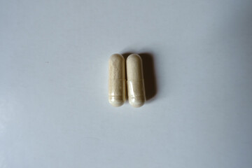 Pair of light beige capsules of Saccharomyces boulardii probiotic from above