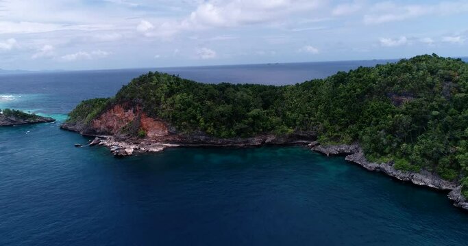 Aerial shot of tropical island with patch of red rocks and turquoise water