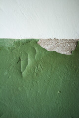 Wall texture with peeling green and white paint, painted old wall closeup