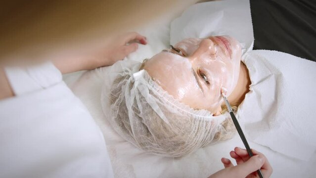Вeautician cosmetologist doing procedure fractional microneedle mesotherapy with Dermapen. Hardware cosmetology in clinic salon for client. 