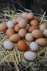 Stack of egg on straw with wooden table background.Top view.