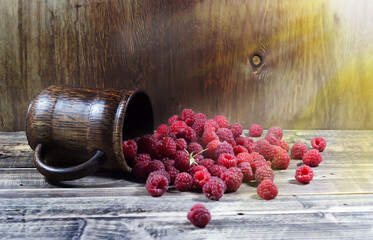 Raspberries in a wooden glass on a wooden background