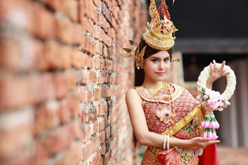Young fashion and beautiful asian woman wearing Thai red traditional costume holding jasmine flower...