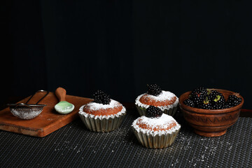 delicious cupcakes with blackberries and powdered sugar