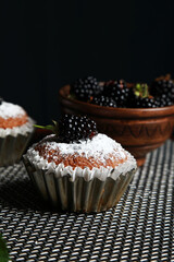 delicious cupcakes with blackberries and powdered sugar