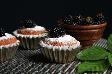 delicious cupcakes with blackberries and powdered sugar