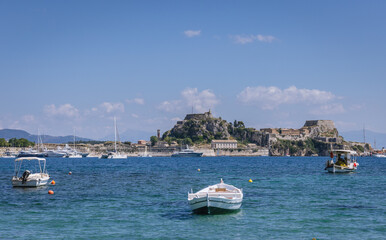 Fototapeta na wymiar Boat on Garitsa Bay in Corfu town on Corfu Island in Greece, Old Fortress on background