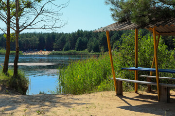 Small beach with a gazebo on the lake on a summer sunny day