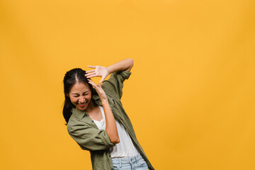 Portrait of young Asia lady with positive expression, smile broadly, dressed in casual clothing over yellow background. Happy adorable glad woman rejoices success. Facial expression concept.