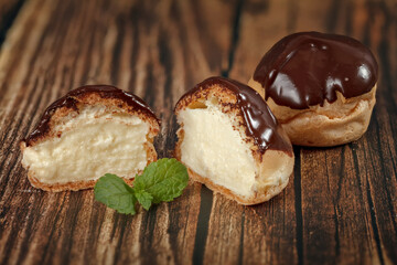Homemade pastry, profitroli with custard on wooden table