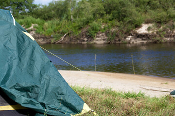 Tent camp on the river bank. A fragment of the tent is visible. Close-up.