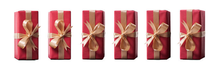 Top view of Christmas presents wrapped in red paper with gold ribbon and bow decoration isolated...