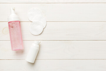 Micellar cleansing water and discs to remove cosmetics and cleanse the skin on colored background. Copy space top view