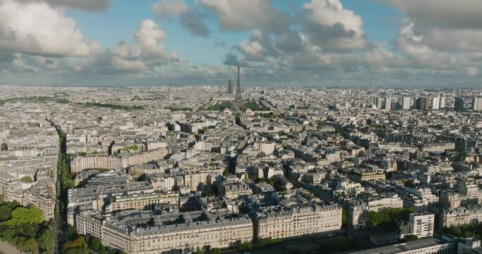 Aerial drone distant sunset view of Tour Eiffel Tower and Seine River bridge traffic cars driving, Paris city attractions, France