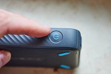 close up of finger pushing power-on button