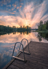 Beautiful sunset in tranquil lake at summer evening in Finland with pier - 523191514