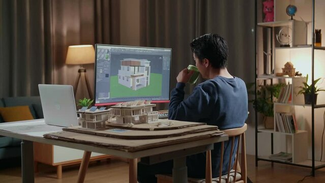 Asian Male Engineer Drinking Coffee While Designing House On A Desktop At Home. Cyber Games House Design And Decoration
