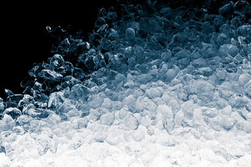 Pieces of crushed ice cubes on black background. Crushed ice heap with copy space.