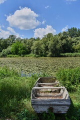 Old wooden boat on a river bank on a sunny summer day