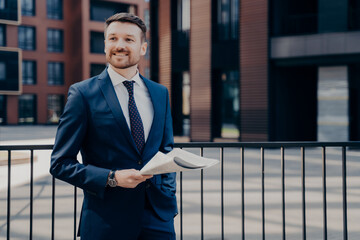 Fototapeta premium Happy office worker on break standing while holding newspaper