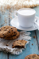 Chocolate chip cookies and a cup of latte on a blue wooden table