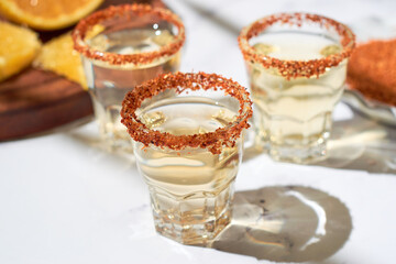 Mexican mezcal shots with slice of orange fruit adn chili