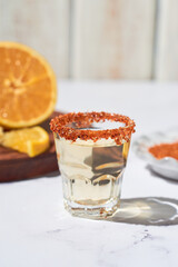 Mexican mezcal shots with slice of orange fruit adn chili