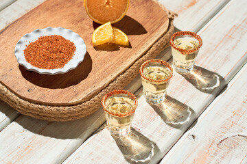 Mexican mezcal shots with slice of orange fruit adn chili