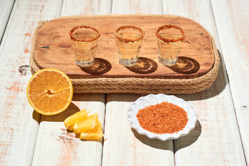 Mezcal shot mexican drink with orange slices and chili pepper