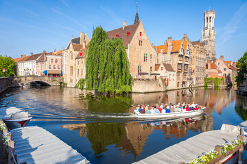 Naklejka premium Boat cruise crossing Rozenhoedkaai canal with reflection, Bruges