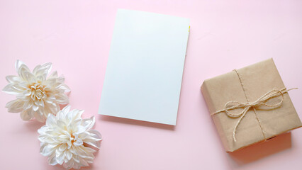 white blank card , gift box and white flower on pink background