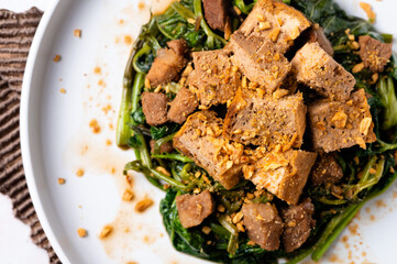 Adobong Kangkong (Water spinach) topped with fried tofu and pork sprinkled with toasted garlic bits